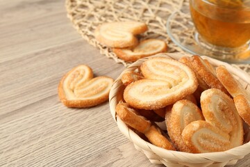 Delicious palmier cookies with tea on wooden table