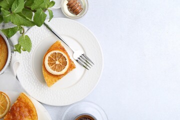 Slice of tasty semolina cake served on white table, flat lay. Space for text
