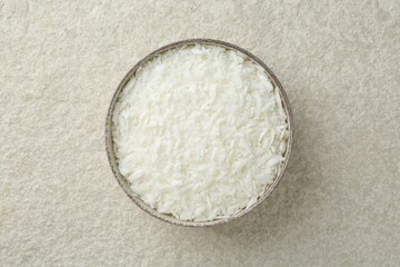 Soy wax in bowl on white textured table, top view