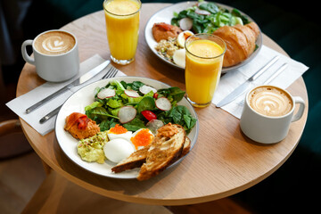 Tasty breakfast. Different meals and drinks served on wooden table in cafe, closeup