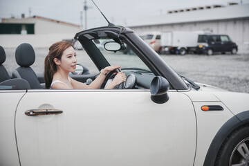 Woman driving in a convertible car.