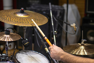 Close up of hand holding drum stick and playing drums in studio on rehearsal.