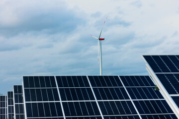 Solaranlage und Windrad bei wolkigem Himmel