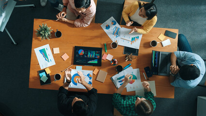 Top down view of investor brainstorming while looking at financial statistic document. Group of...