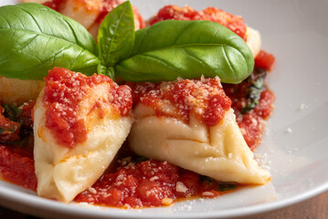 Culurgionis ripieni di patate, pecorino e menta e conditi con sugo, classica ricetta di pasta della cucina Sarda cibo italiano 