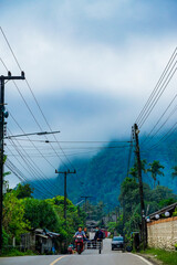 Biking through foggy mountains rural road scenic photography serene environment wide angle nature's beauty revealed