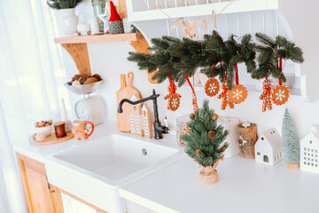 Cozy kitchen decorated for Christmas with ornaments and a small tree