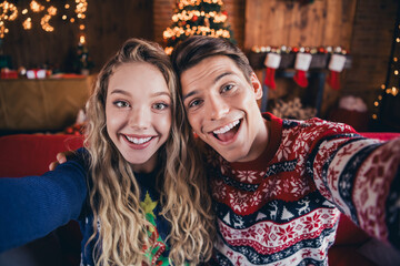 Photo of attractive excited couple wear print jumpers tacking selfie celebrating xmas indoors room home house