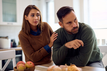 Frustrated man ignoring his wife after  argument at home.