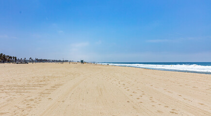 California USA. People on sandy Venice beach. Pacific ocean coastline Los Angeles. Blue sky