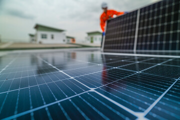 A worker in an orange safety jacket inspects solar panels on a rooftop, using a laptop to ensure...