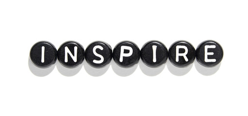 Inspire word in black letter beads on white background for motivation and creativity concepts