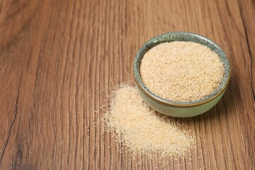 Oat bran in bowl on wooden table, closeup. Space for text