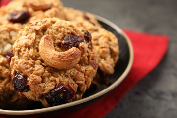 Delicious oatmeal cookies with raisins and nuts on grey table, closeup