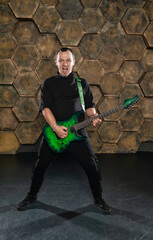 Intense electric guitarist performing with passion against a hexagonal backdrop