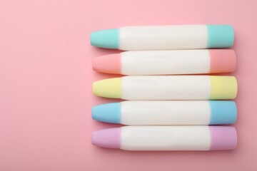 Sticks of glue on pink background, flat lay. Space for text