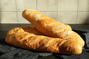 Freshly baked baguettes on black table, closeup
