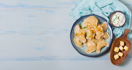 Dumplings filled with mashed potatoes. Varenyky, vareniki, pierogi, pyrohy - dumplings with filling. View from above, top studio shot with copy space