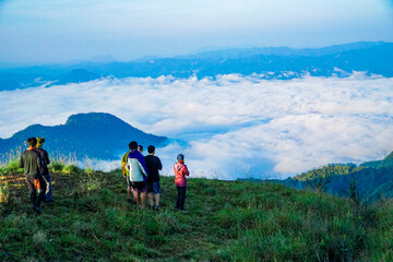 Adventurous group hike mountain summit scenic landscape early morning breathtaking views nature connection