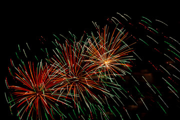 Pink gold sparks of fireworks on black sky