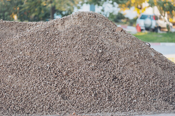 crushed stone of different fraction. A close-up of a pile of gray gravel with a smooth surface. A lot of construction sand near the site to build