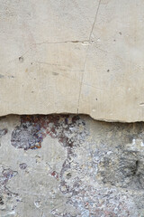 Décollement d'une plaque d'enduit sur un mur