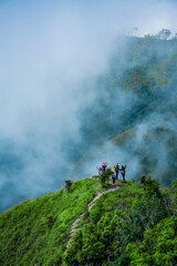 Adventurous hikers exploring misty highlands scenic mountain range outdoor activity lush environment aerial perspective nature's beauty