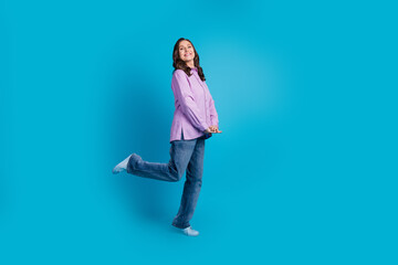 Full length photo of cheerful carefree lady dressed puple blouse smiling empty space isolated blue color background