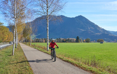 woman riding her electric mountain bike on the Allgaeu mountains , below Gruenten summit near Immenstadt,Bavaria Germany