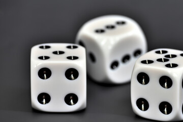 Five white dice with black spots on them. A game with a gray background and dice. Dice game gray background white cube. A cube with white and gray dice lifestyle on a background.