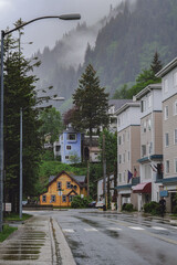 Grey, misty, foggy morning in Juneau Bay, Alaska with small islands channel cruising and houses, glacier mountains and low clouds downtown historic old town shopping district streets