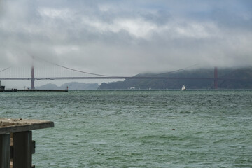 Backlit silhouette of world famous red steel suspension bridge in San Francisco port entrance with...