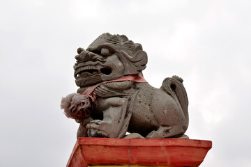 A white lion statue sits on a red block, a white sky background