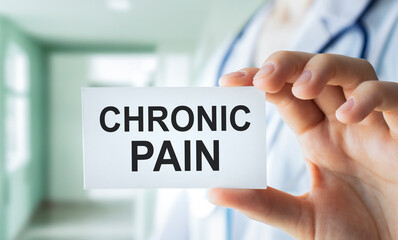Doctor keeps a card with the name of the diagnosis - chronic pain. Selective focus. Medical concept.