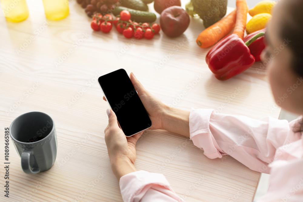 Leinwandbilder breakfast concept. over the shoulder above view of young female holding in hand device with black em