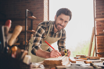 Photo of young man hobby love to make by himself crafting furniture with his hands ruler and pencil measure plank indoors workshop