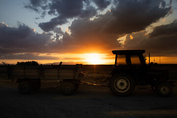 Fototapeta premium magnificent sunset and tractor view in agricultural field