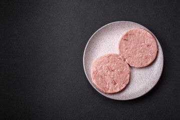 Raw chicken burger cutlet with salt, spices and herbs