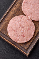 Raw chicken burger cutlet with salt, spices and herbs