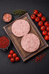 Raw chicken burger cutlet with salt, spices and herbs