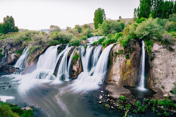 Muradiye Waterfall. Beautiful waterfall view in summer. The waterfall is a natural wonder that flows naturally among lush green trees near Lake Van. Van, Turkey.