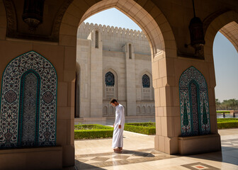 Man in Dishdasha Walking Through Grand Sultan Qaboos Mosque in Muscat, Oman