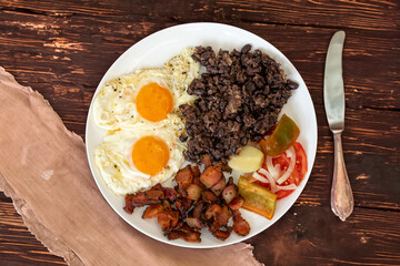 Traditional Brazilian everyday food, black bean stew, bacon, egg, salad, pickles. Real rustic food