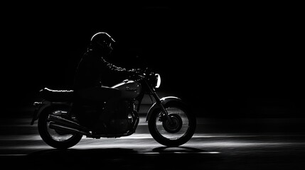 Fototapeta premium Silhouette of a motorcyclist riding at night.