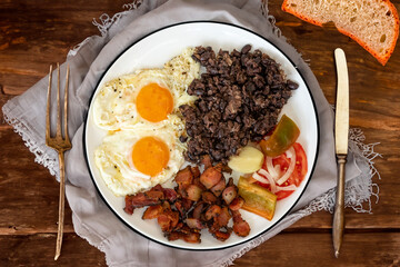 Traditional Brazilian everyday food, black bean stew, bacon, egg, salad, pickles. Real rustic food