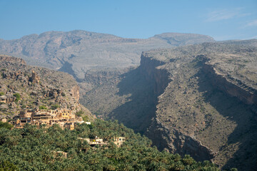 Obraz premium Misfat Al Abriyeen is a picturesque mountain village in Oman, known for its ancient mud-brick houses, lush terraced farms, and intricate falaj irrigation system.