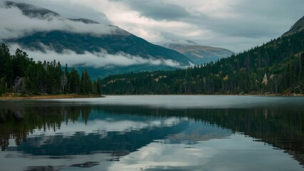 Fototapeta premium Misty Mountain Lake: Serene mountain lake reflecting the misty mountains and lush green forests, creating a breathtaking and tranquil landscape.