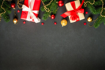 Black Christmas flat lay background with present, fir tree and holiday decorations. Copy space for design.