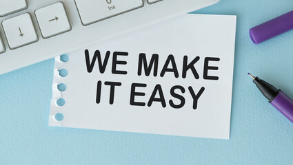 We make it easy text in the notebook on a blue table. Top view - business concept.