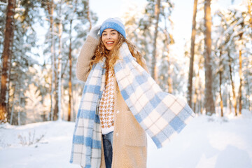 Portrait of a happy woman playing with snow on a sunny winter day. Concept of fun, relaxation. Nature, holidays, travel concept.